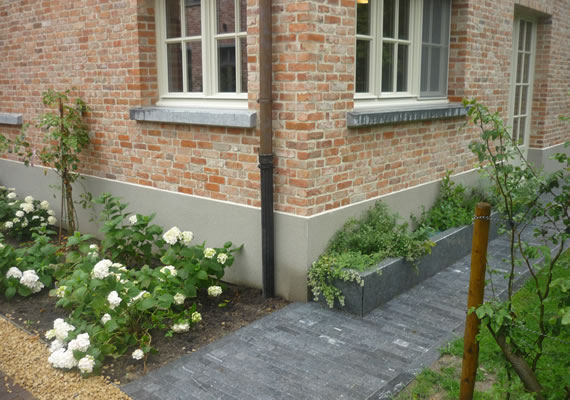 De woning is rondom afgewerkt met een cementplint dewelke als afwerking egaal gekrast is.